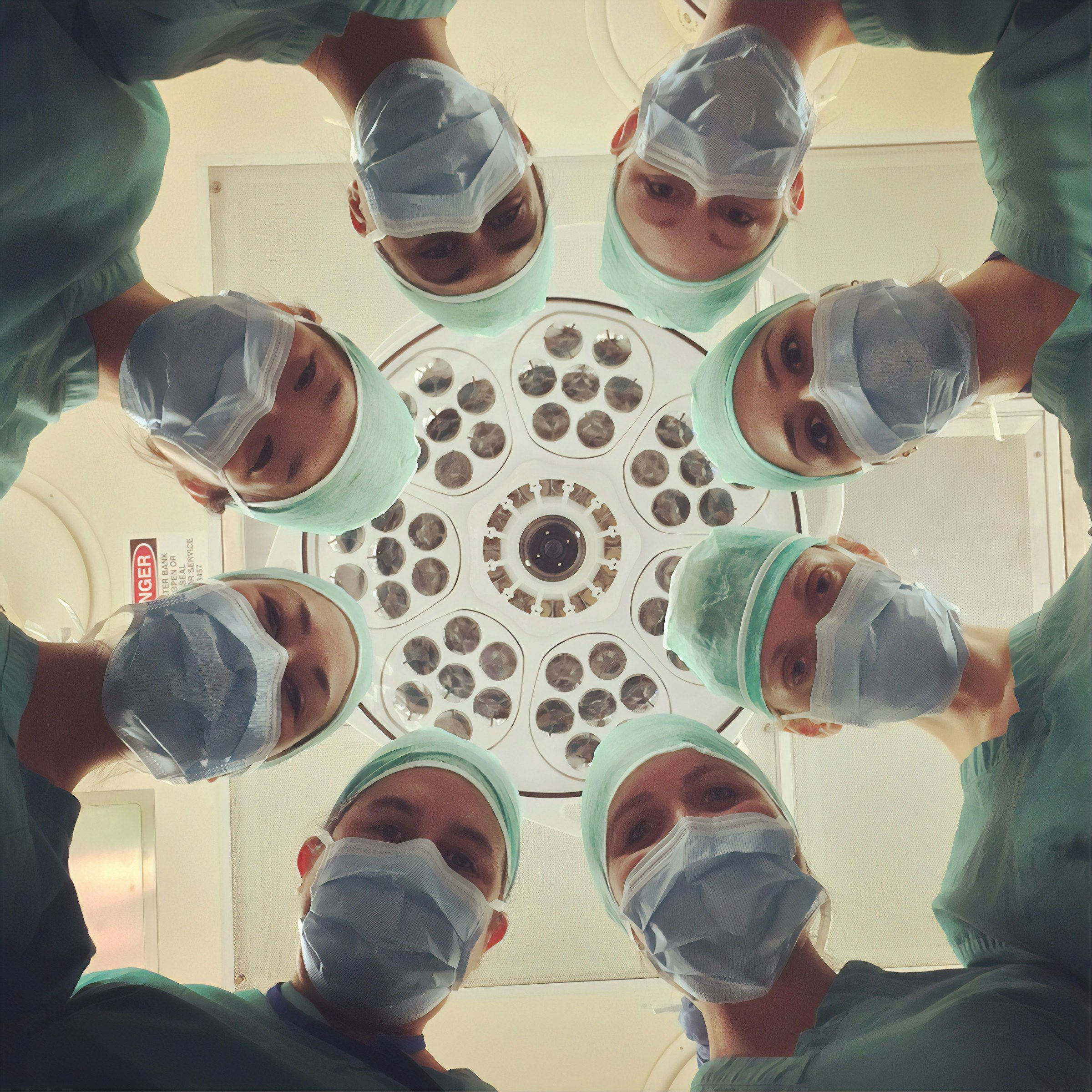 A focused medical team gathered in a clinical setting, conveying concentrated professional expertise.